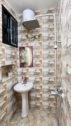 a bathroom with a sink and a mirror at Rosewood Cozy homes in Mbeya