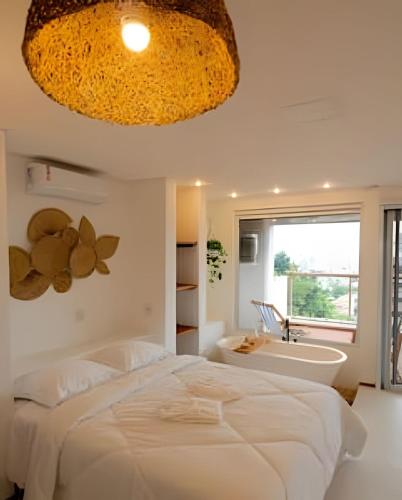 a bedroom with a large bed and a bath tub at Artha Home Spa in Governador Celso Ramos