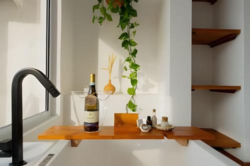 a bottle of wine sitting on a wooden counter next to a sink at Artha Home Spa in Governador Celso Ramos