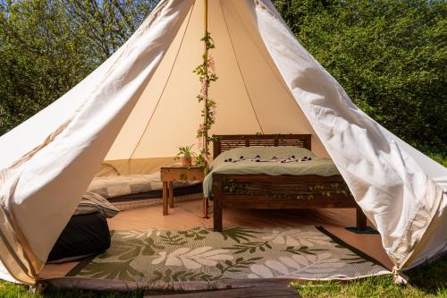 a canvas tent with a bed in it at Battle Pods and Bells Glamping in Battle