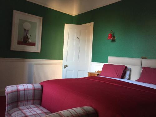 a bedroom with a red bed and a chair at Moorlands in Helensburgh