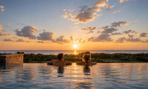 a man and woman in a infinity pool watching the sunset at Marea Villas Heated Pool in Dhrámia