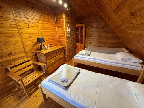 a bedroom with two beds in a wooden cabin at Sowa i Kumple in Drezdenko