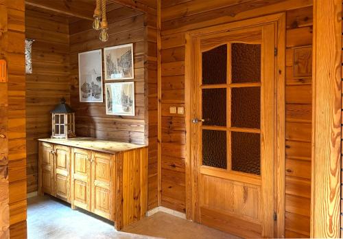 a kitchen with wooden walls and a wooden door at Sowa i Kumple in Drezdenko