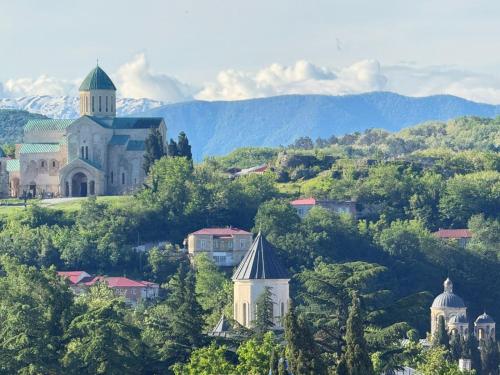 a church on top of a hill with trees at Seventh Floor Apartment in Kutaisi