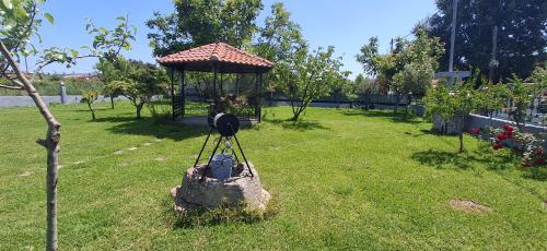 a garden with a gazebo in the grass at Kanela House ,Cozy Cottage with Large Garden & BBQ in Nea Kallikrateia