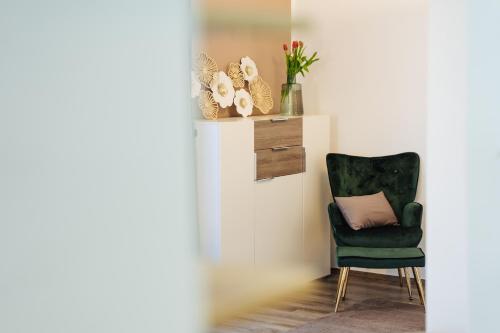 a green chair with a pillow in a room at Boutique Apartments Daniela in Faak am See