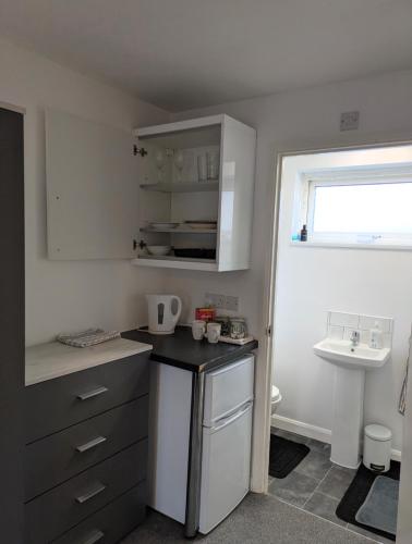 a small kitchen with a sink and a counter at Corby Double & En-suite Rooms NN17 2LZ area Ideal Contractors Short & Long stays Opposite Lodge Park Leisure Center in Corby