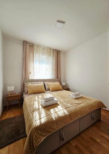 a bedroom with a large bed with two towels on it at Apartmani Marija - Vila Marija in Šilo