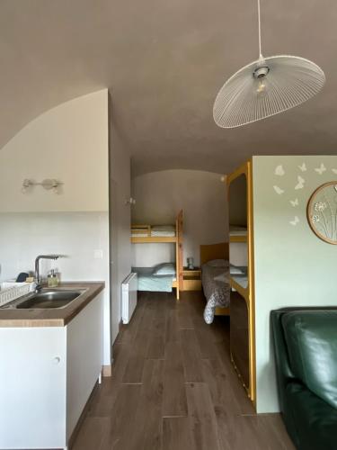 a room with a sink and a kitchen with a bedroom at voute atypique 40 m2 in Montaigut-le-Blanc