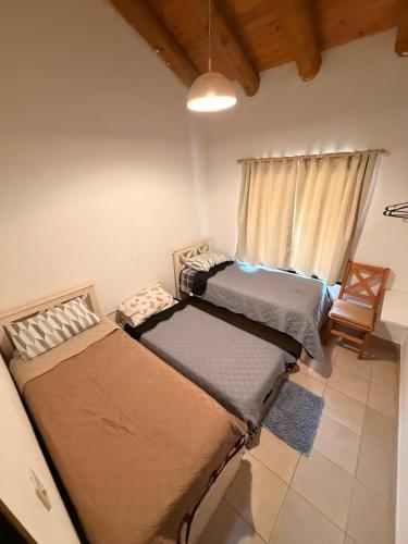 two beds sitting in a room with a window at La Casita El Martillo in Concordia