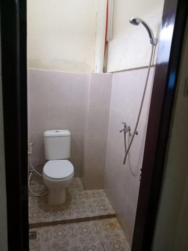 ein Badezimmer mit Toilette und Dusche in der Unterkunft Hotel Brawijaya in Timuran