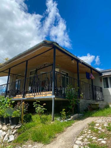 a house with a balcony on the side of it at Mta House Racha in K'veda Shavra