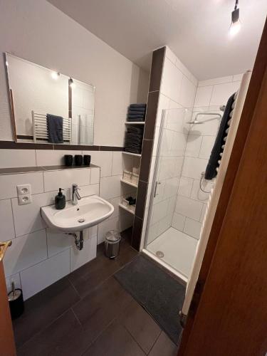 a white bathroom with a sink and a shower at Ferienwohnung Marcello in Adenau