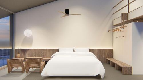 a bedroom with a large white bed and chairs at Rucha Beachfront Retreat in Ấp An Lộc A