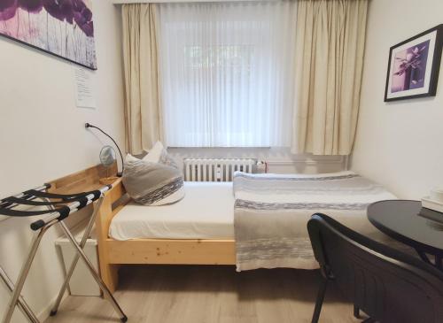 a small room with a bed and a desk and a window at Unterkunft Ramser in Bad Eilsen