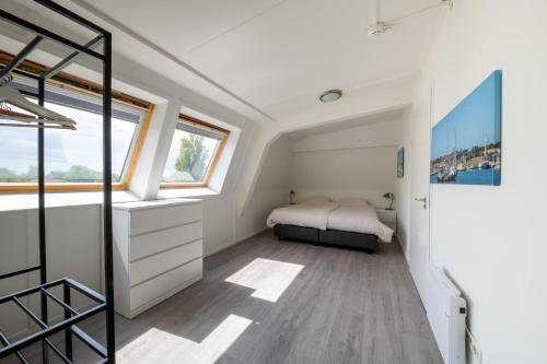 a bedroom with a bed and a window at Waddenresidentie Ameland - 2 en 4 persoons appartementen in Buren