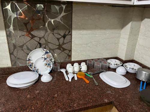 a kitchen counter with white plates and a sink at 2BHK Ground Floor Private House- Raj Shila in Kānpur