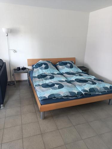 a bed with a blue comforter in a room at Tengs in Triboltingen