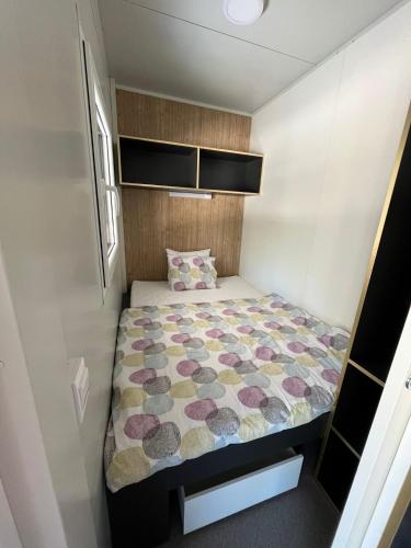 a small bedroom with a bed in a trailer at Emil 8 in Pakoštane