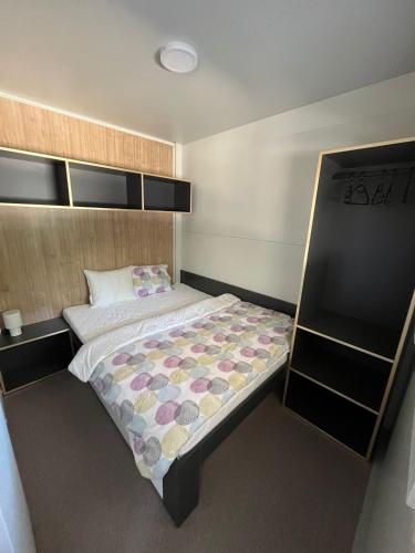 a small bedroom with a bed and a shelf at Emil 8 in Pakoštane