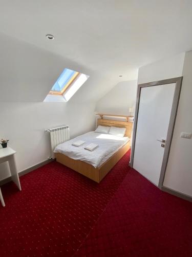 a small bedroom with a bed and a window at Casa Nelda in Marginea