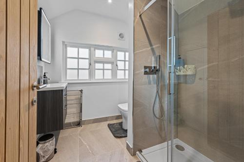 a bathroom with a shower and a toilet at Modern & Historic Mill Flat with Stream Views in Godalming