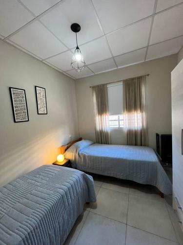 a bedroom with two beds and a window at Apart Los Laureles in Villa Regina