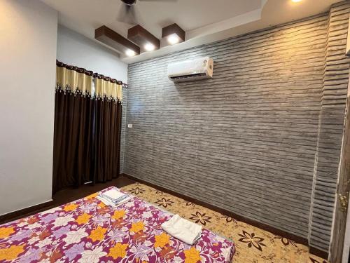 a bedroom with a bed and a brick wall at 2BHK Ground Floor Private House- Raj Shila in Kānpur