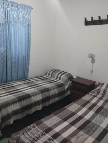 two beds sitting next to each other in a bedroom at El Sitio Azul Cabañas in Esquina