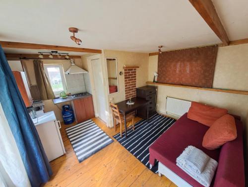 a living room with a couch and a kitchen at Peaceful Cottage With Garden in Saulkrasti