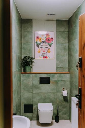 a bathroom with a toilet and a painting on the wall at Sztuka Gór in Nowa Ruda