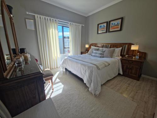 a bedroom with a bed and a desk and a window at Caledonia Guest Room in Trichardt