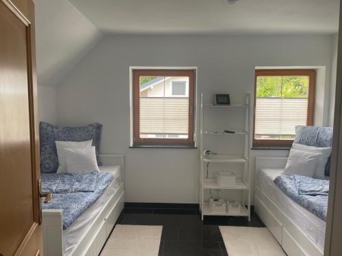 a bedroom with two beds and two windows at Ferienwohnungen Tarmann in Bodensdorf