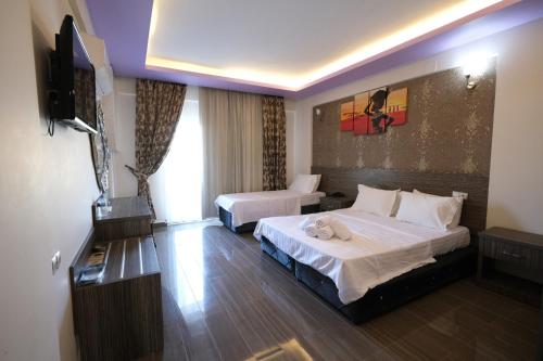 a hotel room with two beds and a flat screen tv at TRUVA LİFE OTEl in Samandağı