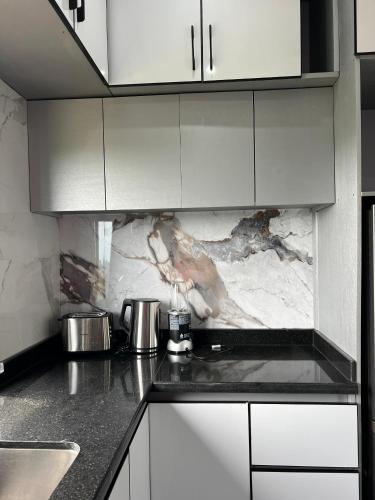 a kitchen with white cabinets and a counter top at T&J Harmony Lodge in Limbe