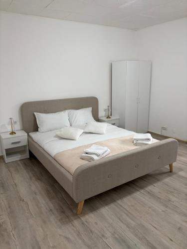 a white bedroom with a large bed with two towels on it at Danuvia Studio 2 in Drobeta-Turnu Severin