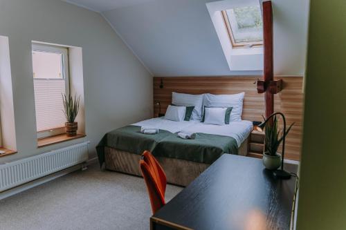 a small bedroom with a bed and a table at Sztuka Gór in Nowa Ruda