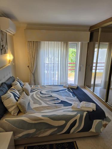 a large bed in a bedroom with a large window at Sol Apartments in Vilamoura