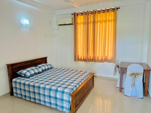 a bedroom with a bed and a table and a window at La Margaritha Hotel & Banquet Hall in Udugampola