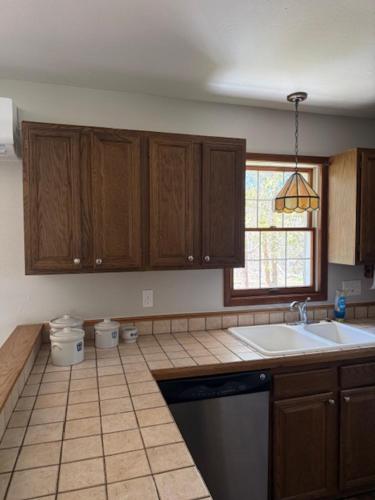 a kitchen with wooden cabinets and a sink and a window at Parkside Inn in Ellison Bay