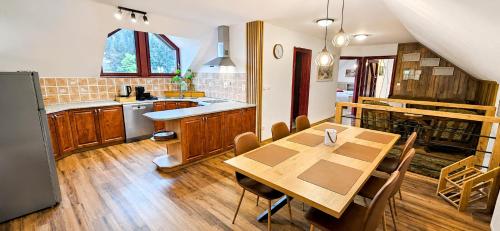 a kitchen with a wooden table and a dining room at Apartmán pod Skalou in Vysoká nad Kysucou