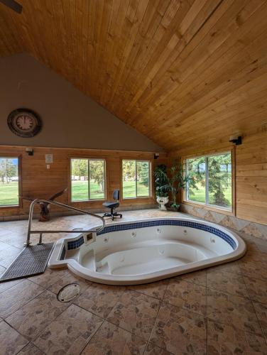 a large tub in a room with a wooden ceiling at NV Mountainview Chalets & RV Resort in McBride