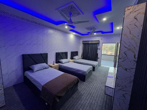 a room with two beds with blue lights on the ceilings at Ajk bed & Breakfast in Gura Gujarān