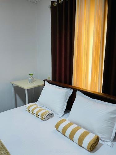 a bed with two pillows on top of it at Mountain Lodge Ella in Bandarawela