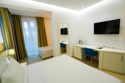 a hotel room with a bed and a desk and a television at Prestige Resort in Golem