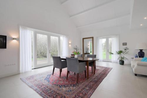a dining room with a table and chairs on a rug at Bij Oriënshuis in Varsseveld