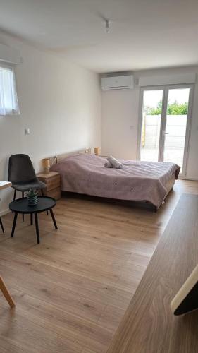 a bedroom with a bed and a desk and a chair at Studio 1 avec extérieur in Saran