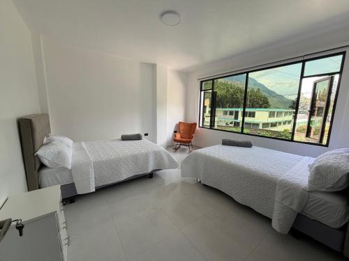 a bedroom with two beds and a large window at DLiam Home in Baños