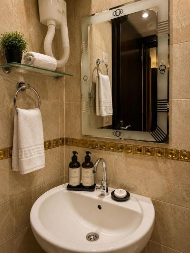 a bathroom with a sink and a mirror and towels at Casa Latina pyramids view in Cairo